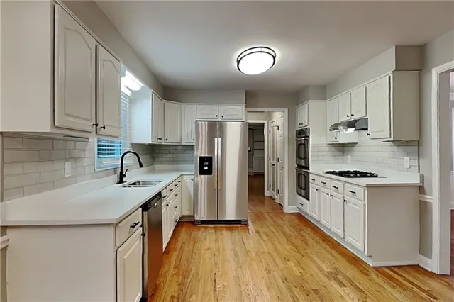 a kitchen with granite countertop a sink stove and refrigerator