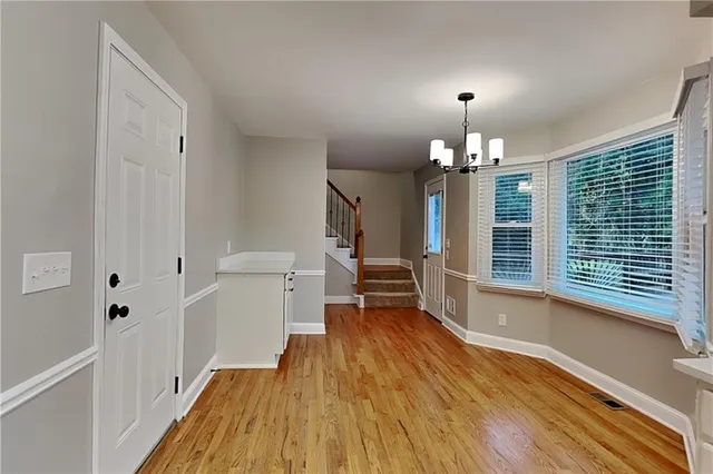 a view of a room with wooden floor a ceiling fan and windows