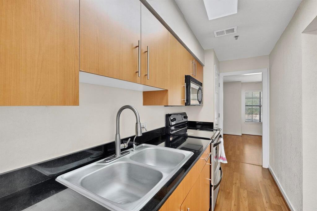 3901 Travis Street, Unit 113 Dallas, TX 75204 - Photo 20 of 40 a kitchen with a sink a stove and cabinets