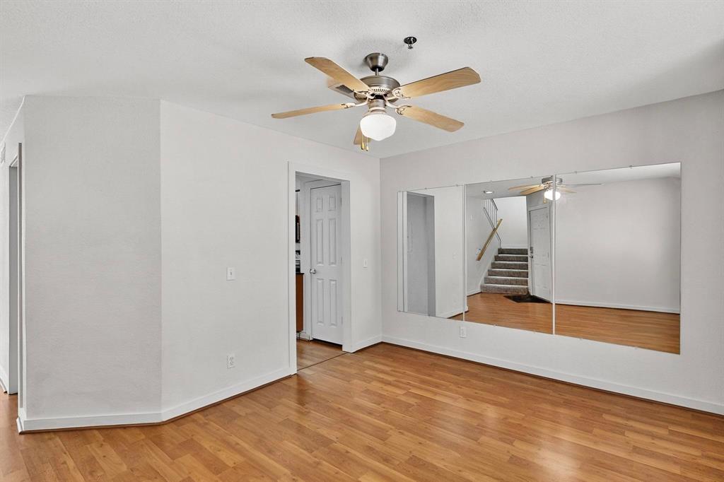 3901 Travis Street, Unit 113 Dallas, TX 75204 - Photo 21 of 40 a view of an empty room with wooden floor and a ceiling fan