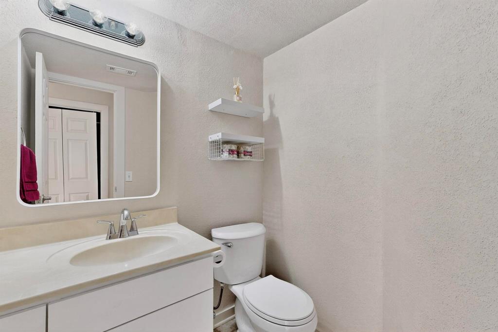 3901 Travis Street, Unit 113 Dallas, TX 75204 - Photo 22 of 40 a bathroom with a granite countertop sink mirror vanity and toilet