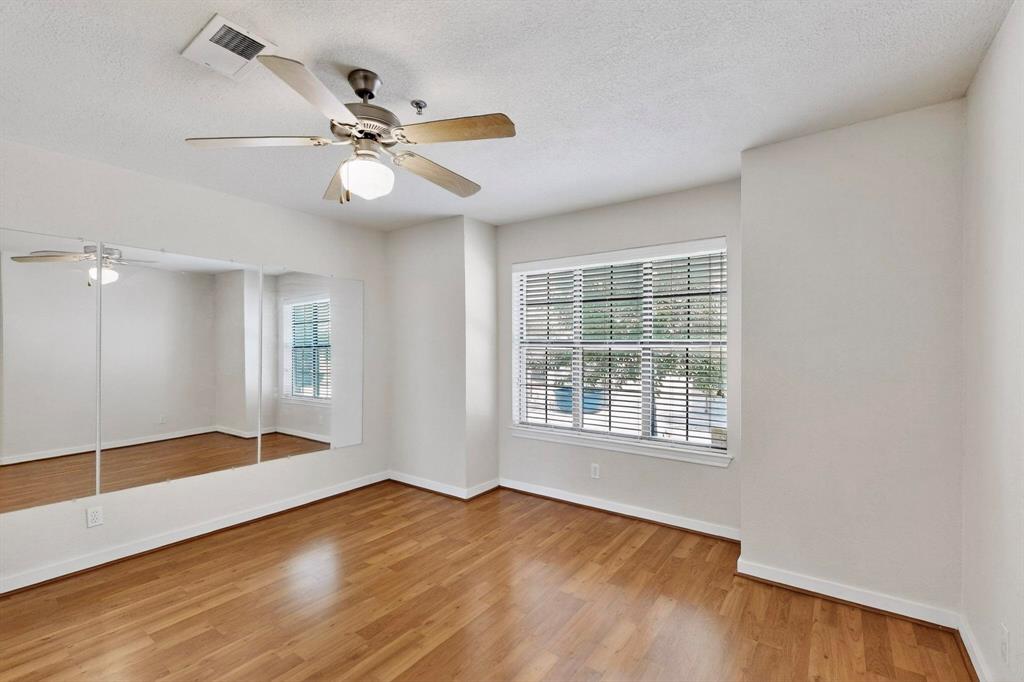 3901 Travis Street, Unit 113 Dallas, TX 75204 - Photo 7 of 40 an empty room with wooden floor fan and windows