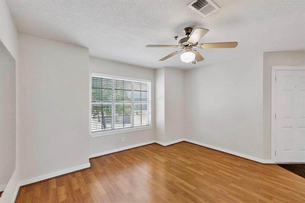 3901 Travis Street, Unit 113 Dallas, TX 75204 - Photo 8 of 40 an empty room with wooden floor fan and windows