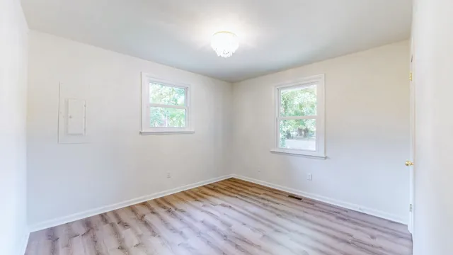 a backyard of a house with large trees and table and chairs