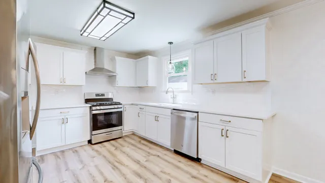 a kitchen with stainless steel appliances a refrigerator and a stove top oven