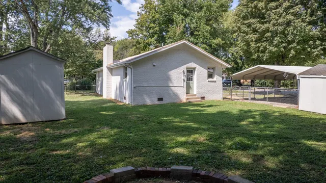 an aerial view of residential house with outdoor space and trees all around
