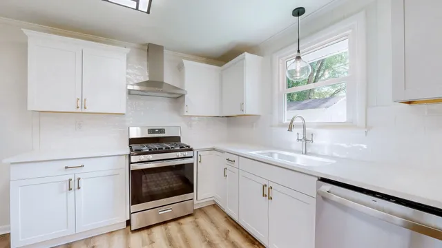 a stove sitting inside of a kitchen with white cabinets