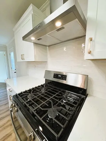 a view of a livingroom with a fireplace a chandelier and wooden floor