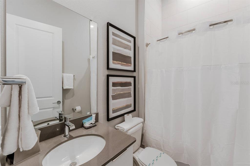 7760 Sandy Ridge Drive, Unit 226 Reunion, FL 34747 - Photo 29 of 40 a bathroom with a granite countertop toilet sink and mirror