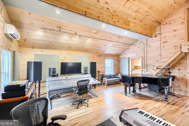 a living room with furniture a piano and a flat screen tv