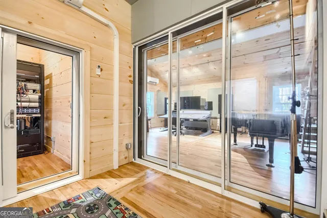 a dining room with wooden floor and a glass door shower