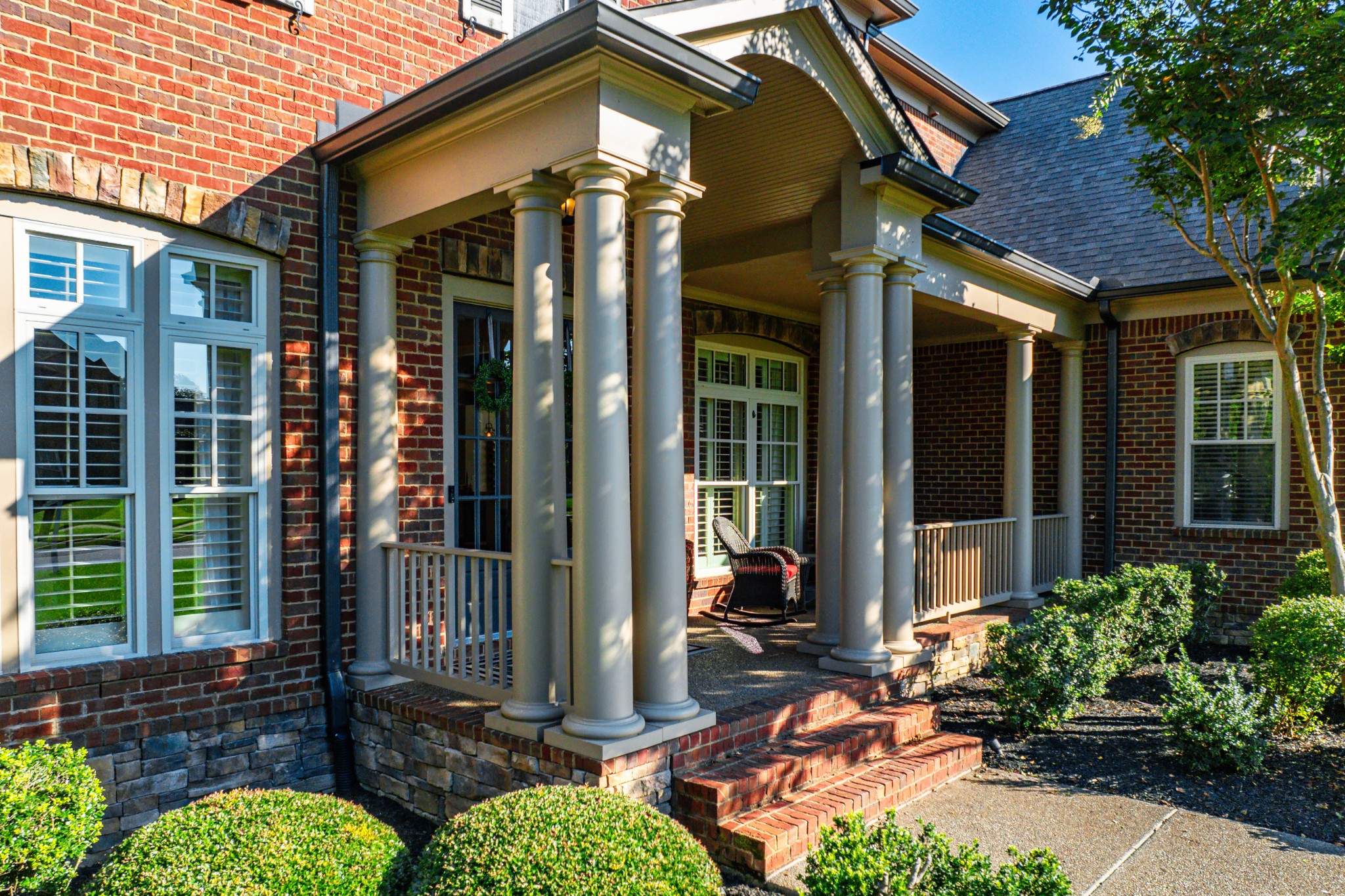 1828 Kettering Trace Brentwood, TN 37027 - Photo 4 of 62 a view of a brick house with potted plants and a bench in front of main door