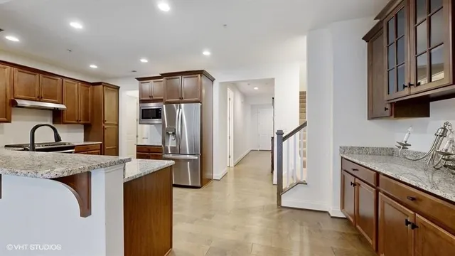 an empty room with wooden floor and windows with curtains