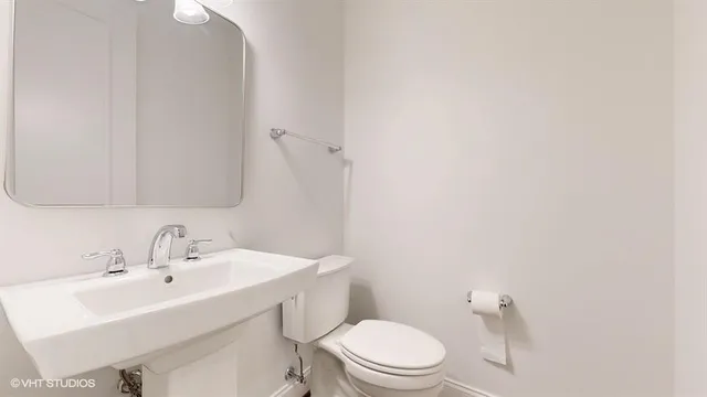 a bathroom with a toilet a sink a tub and mirror