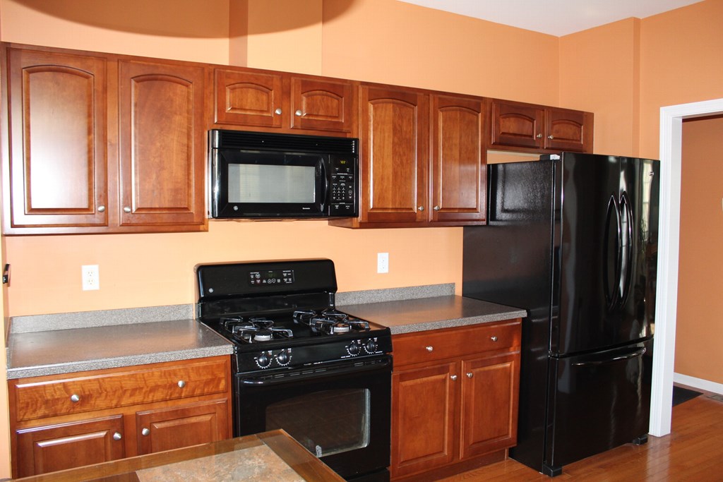101 Buttercup Lane, Unit 101 Grafton, MA 01560 - Photo 14 of 24 a kitchen with stainless steel appliances wooden cabinets and a stove top oven