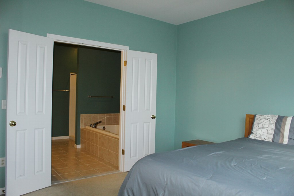 101 Buttercup Lane, Unit 101 Grafton, MA 01560 - Photo 16 of 24 a bedroom with a bed and a refrigerator