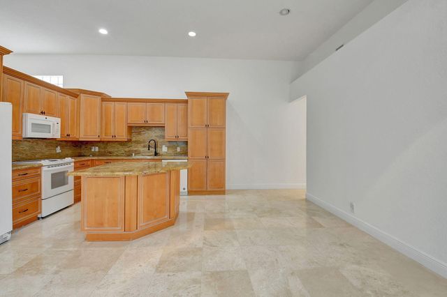 a kitchen with stainless steel appliances a refrigerator a stove a microwave a sink and white cabinets