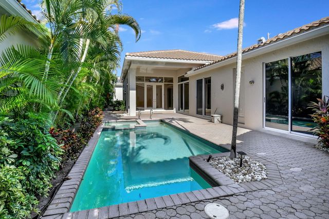 a view of a house with backyard and sitting area