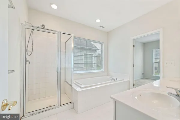 a bathroom with a tub sink and mirror