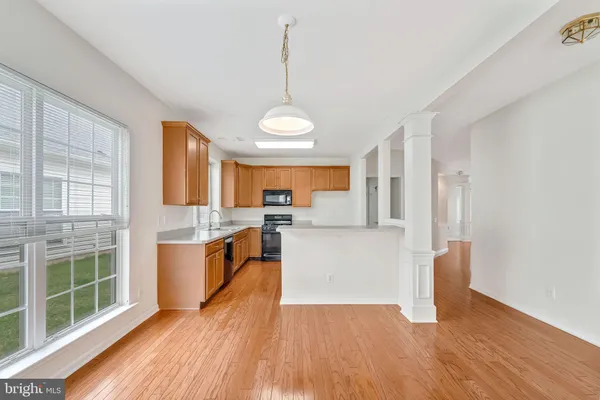 a view of a kitchen with wooden floor and a window