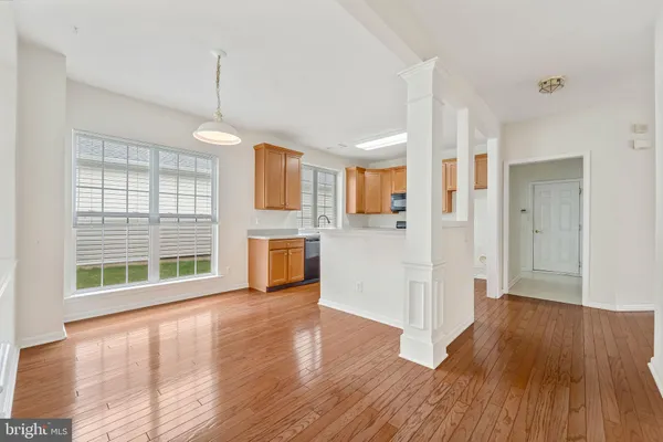 a view of a kitchen with a fridge wooden floor and a window
