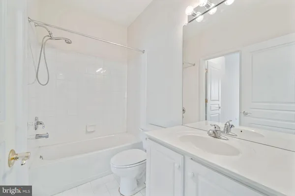 a bathroom with a granite countertop sink a toilet and shower