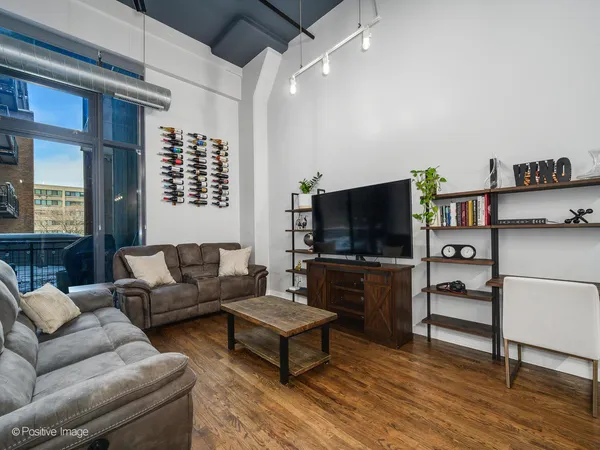 a living room with furniture a flat screen tv and a floor to ceiling window