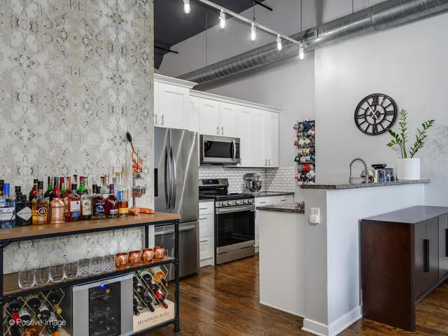 a kitchen with stainless steel appliances granite countertop a refrigerator a stove a sink and a microwave