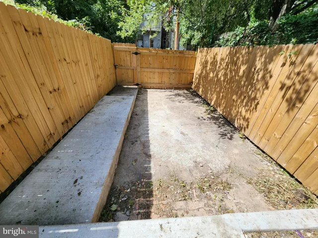 a view of a pathway gate with wooden fence
