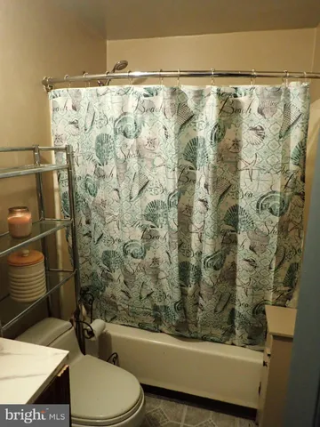 a bathroom with a toilet and a shower curtain