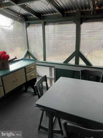 a living room with a table chairs and a bed