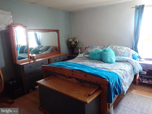 a bedroom with a bed and a mirror on dresser