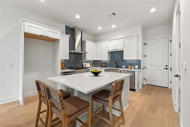 a kitchen with a dining table chairs refrigerator and cabinets