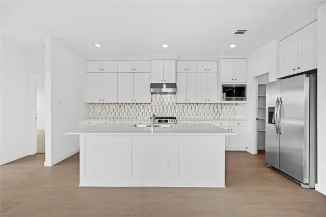 a kitchen with stainless steel appliances a sink stove and refrigerator