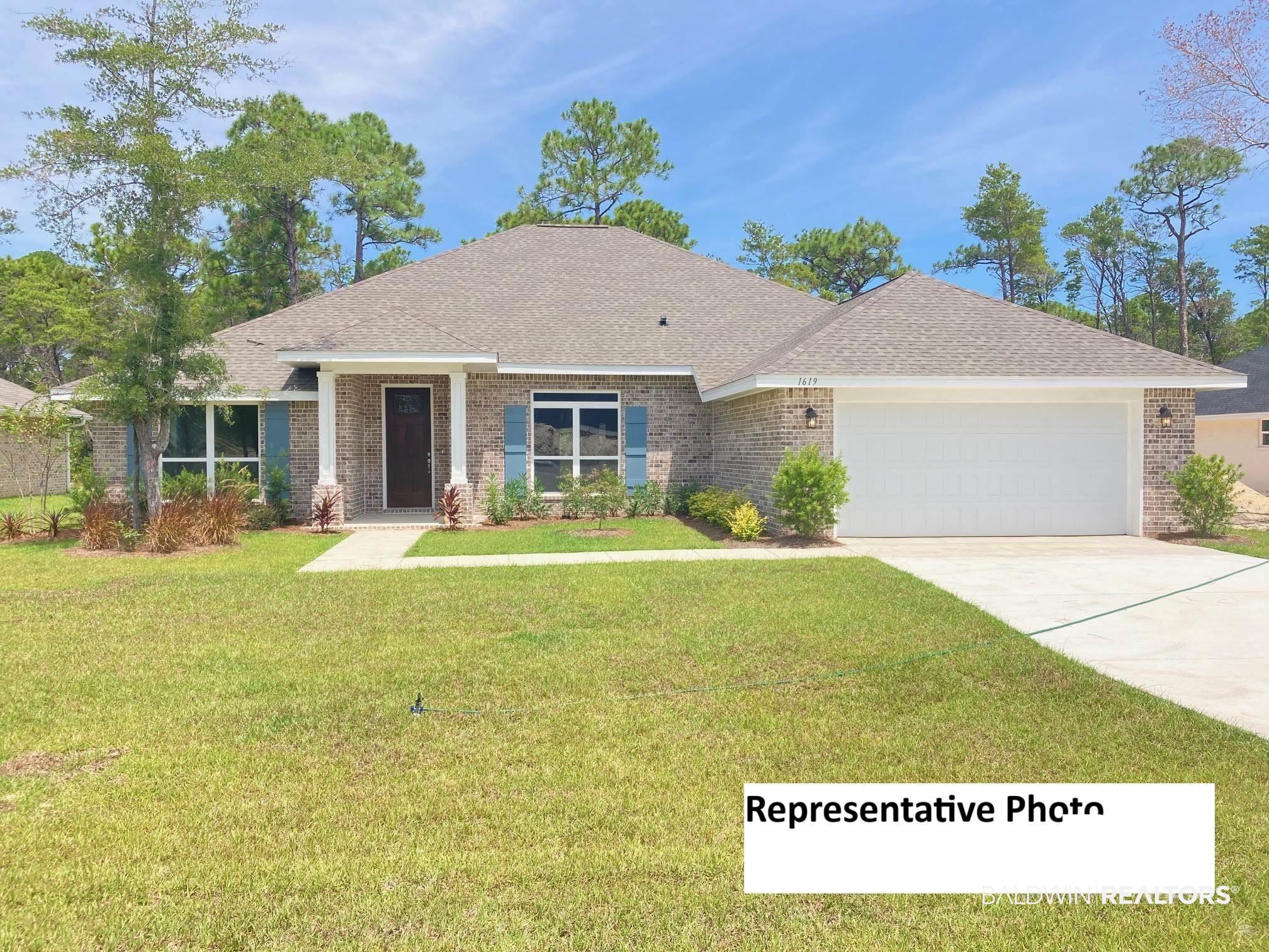 View of front facade featuring a front yard and a garage