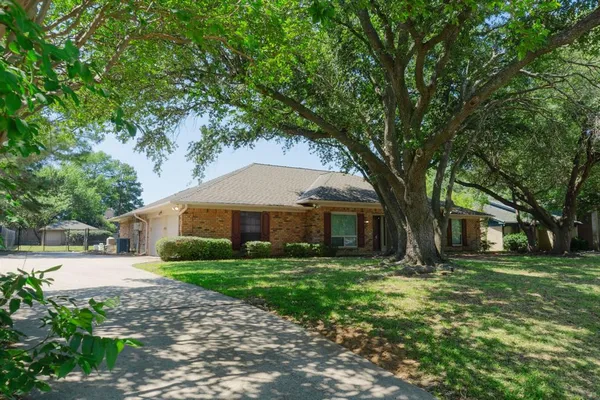 a front view of a house with a yard and trees