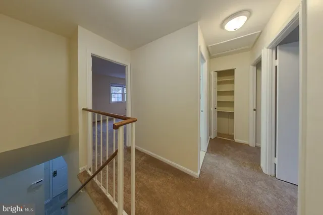 a view of hallway with stairs and wooden floor