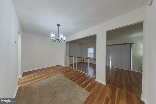 a view of a room with wooden floor chandelier and closet