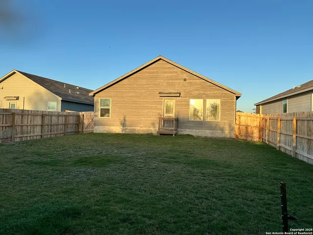 a view of a backyard with wooden fence