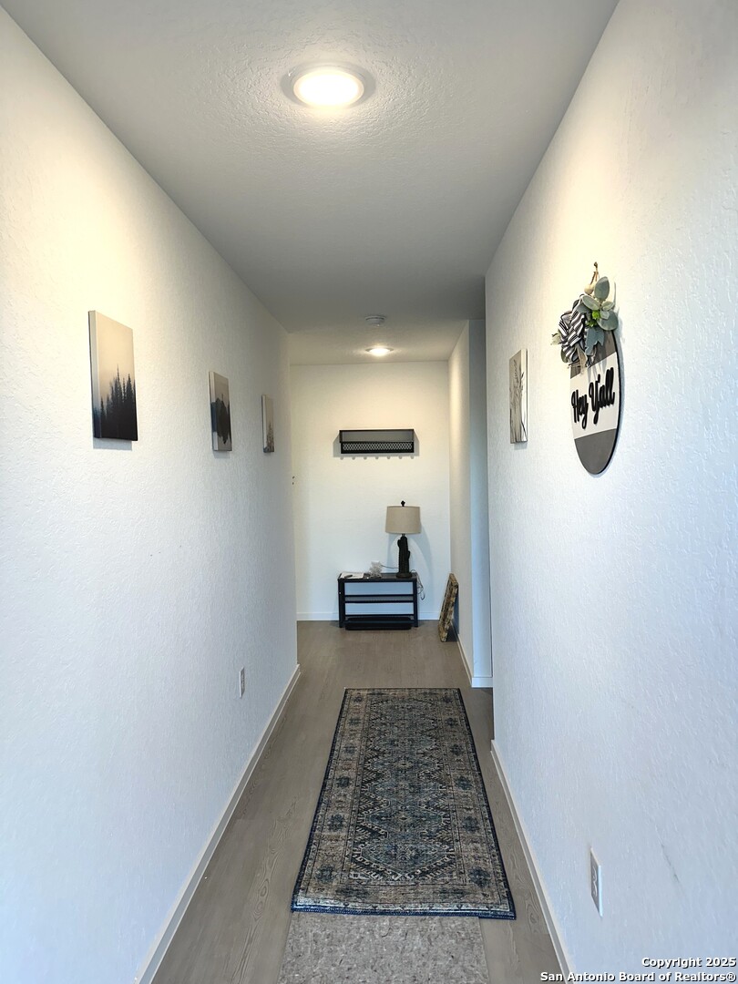 515 Lew Pass San Antonio, TX 78221 - Photo 3 of 26 a view of a hallway with wooden floor