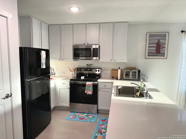 a kitchen with kitchen island a refrigerator stove and microwave