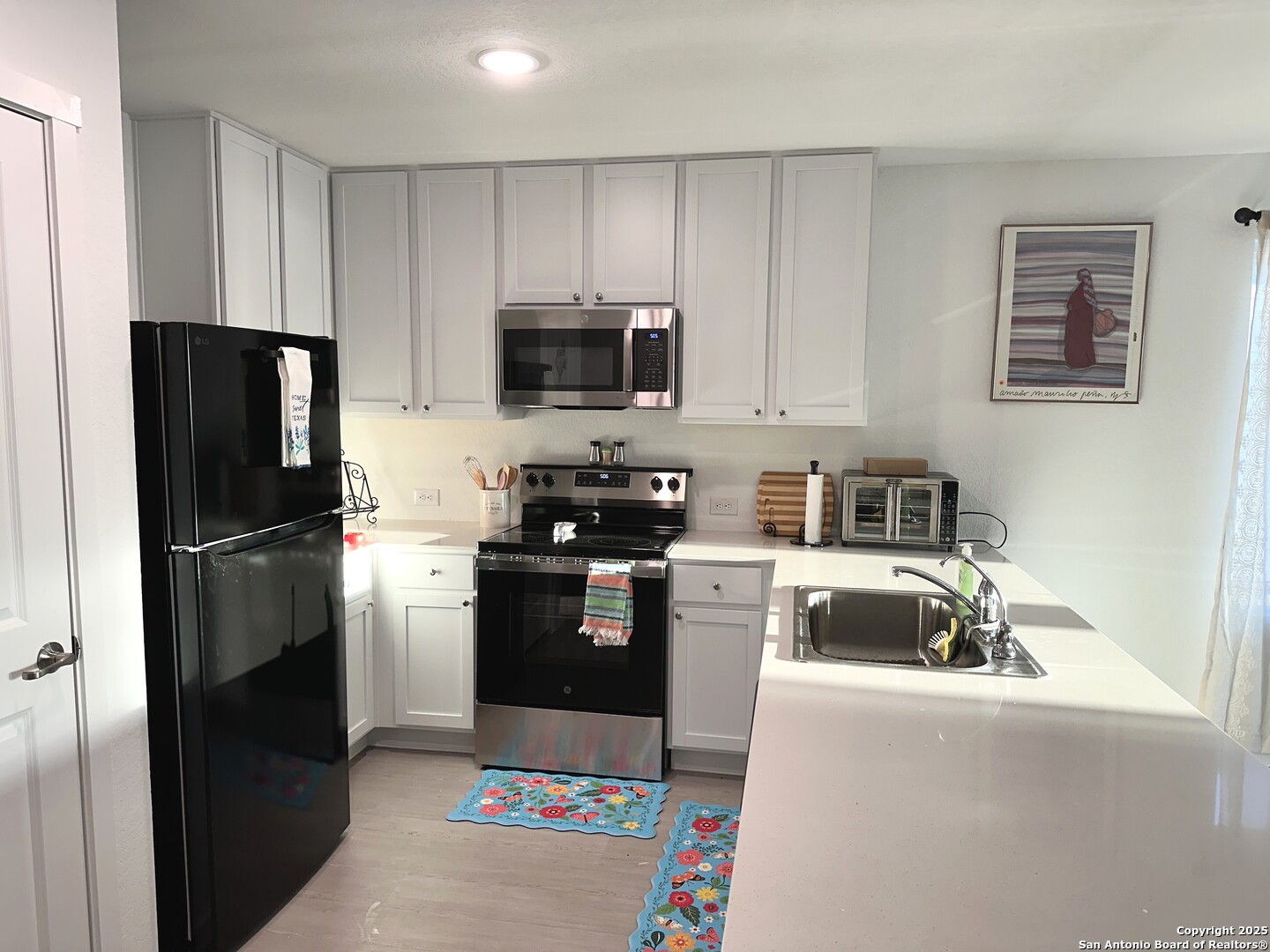 515 Lew Pass San Antonio, TX 78221 - Photo 10 of 26 a kitchen with kitchen island a refrigerator stove and microwave