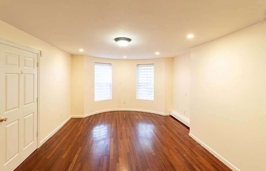 55 East Concord Street, Unit 1 Boston, MA 02118 - Photo 6 of 16 a view of an empty room with wooden floor and a window