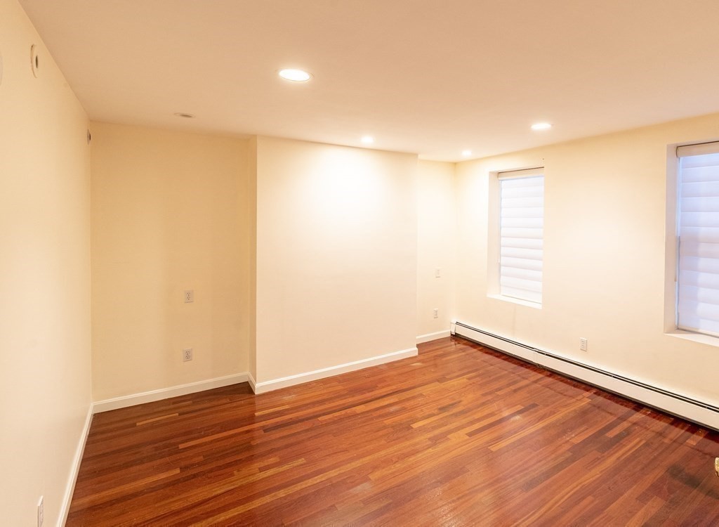55 East Concord Street, Unit 1 Boston, MA 02118 - Photo 7 of 16 a view of an empty room with wooden floor and a window