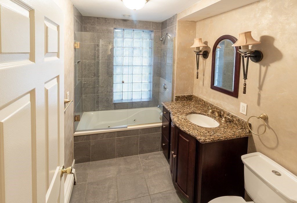 55 East Concord Street, Unit 1 Boston, MA 02118 - Photo 9 of 16 a bathroom with a granite countertop sink toilet and shower