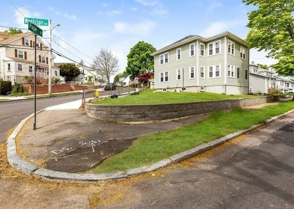 a view of a white house with a yard and plants