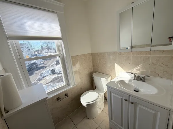 a bathroom with a sink a toilet and a window
