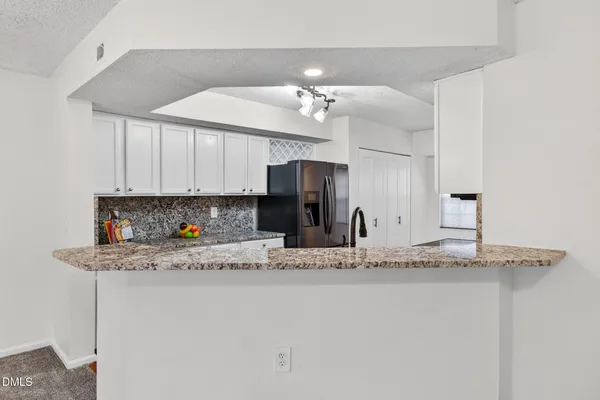 a kitchen with granite countertop cabinets and chandelier