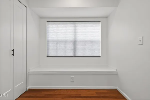 a view of a small space with wooden floor and a window
