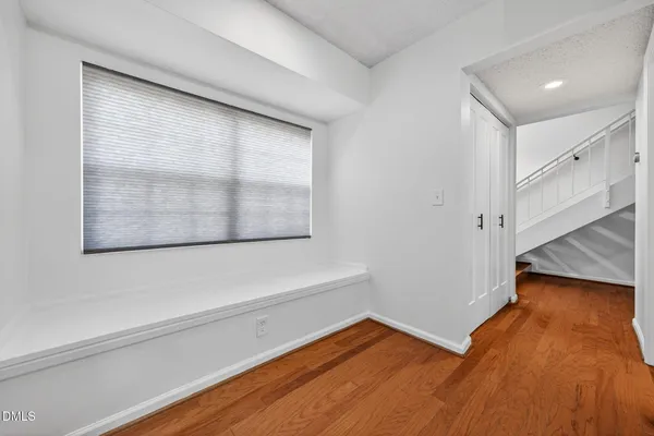 a view of a room with wooden floor and white walls
